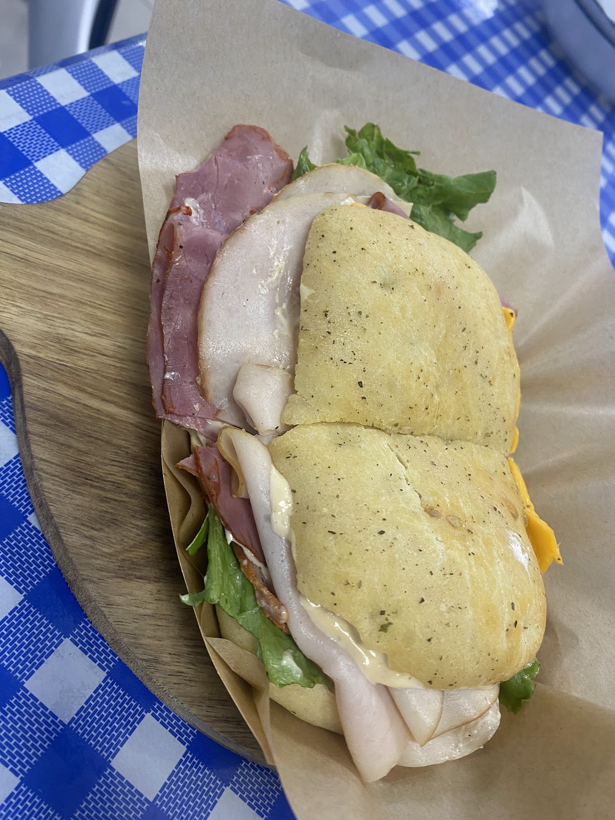 Deli Supreme sandwich with layers of meat and cheese on Schiacciata bread