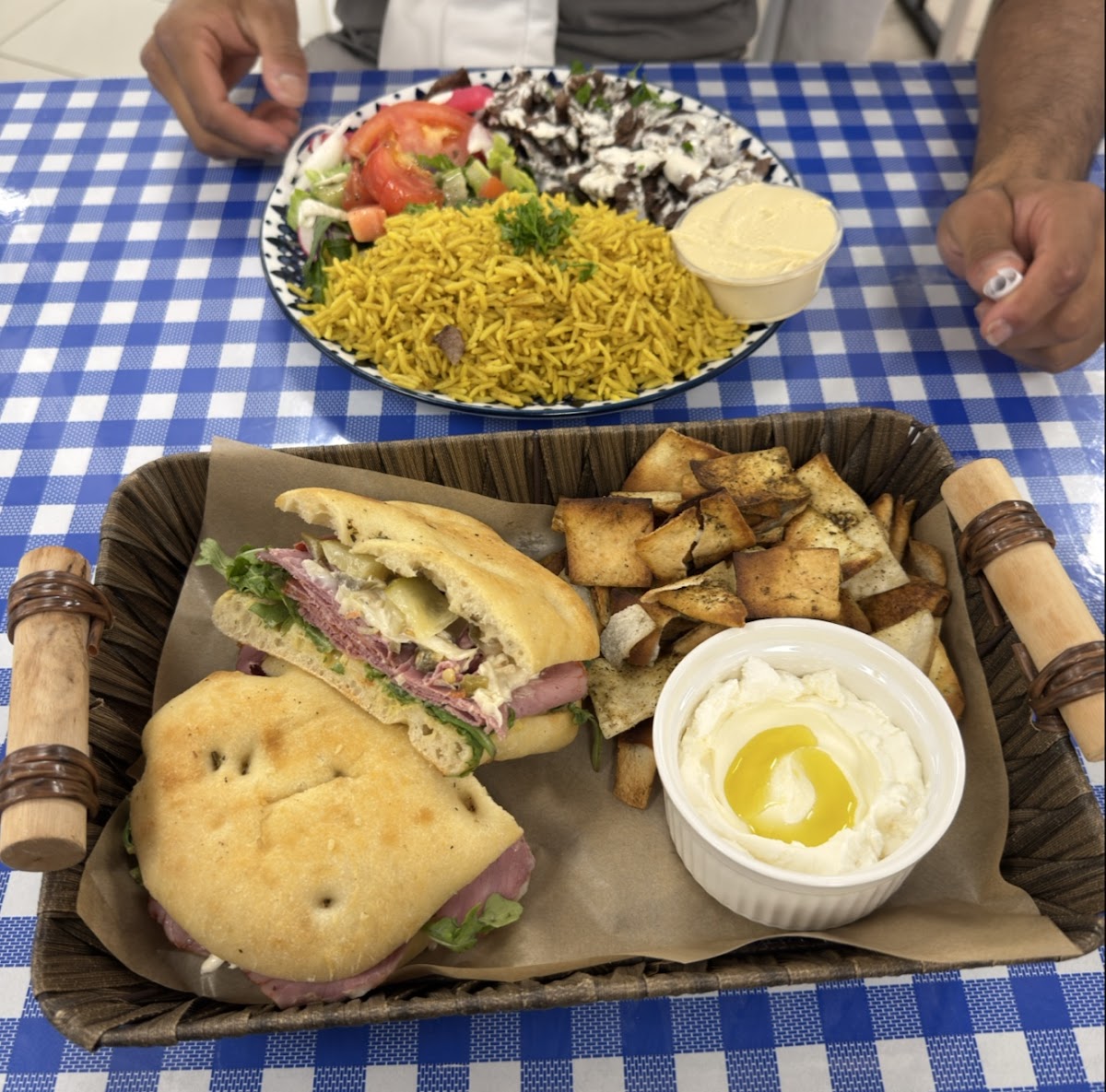Sandwich platter with za'atar chips and labneh on checkered tablecloth