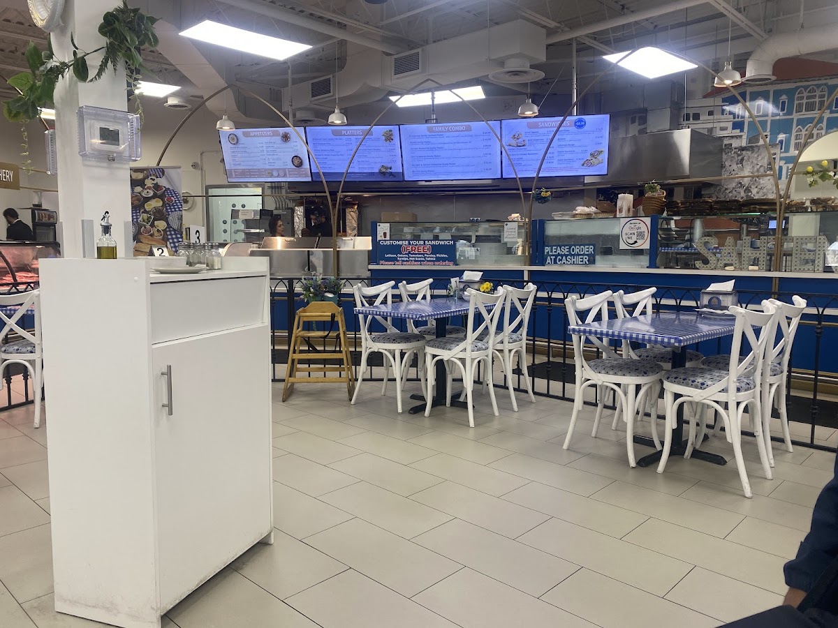El Gourmet seating area with white chairs and blue tablecloths