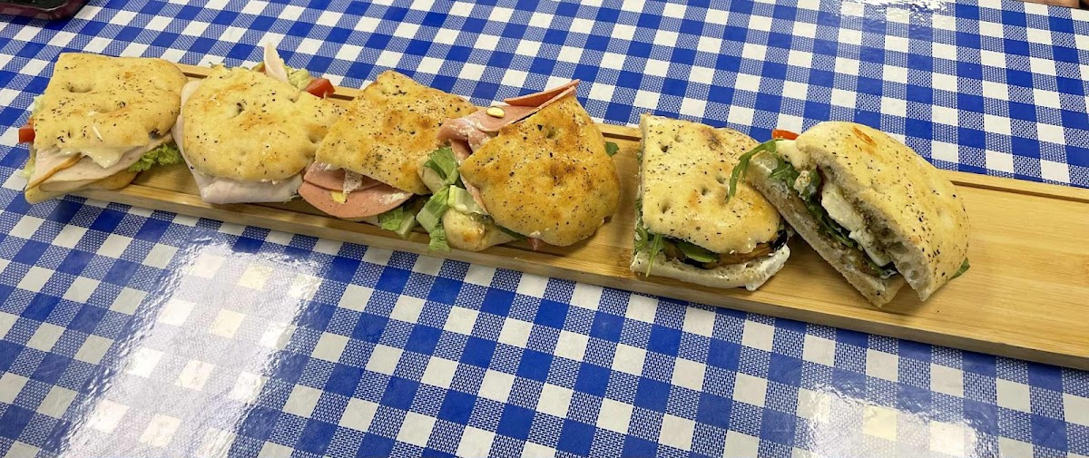 A lineup of different Schiacciata sandwiches on a wooden board
