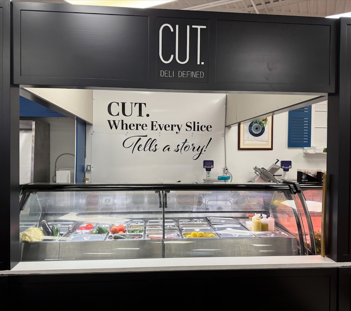 The Cut Deli counter showing the CUT. DELI DEFINED sign and fresh ingredient display