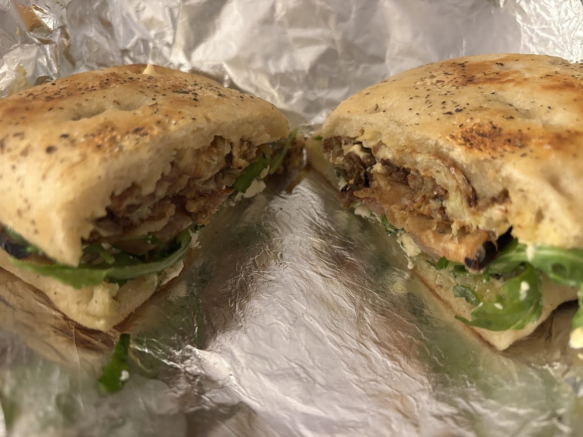 Sandwich halved on Schiacciata bread with arugula and cheese